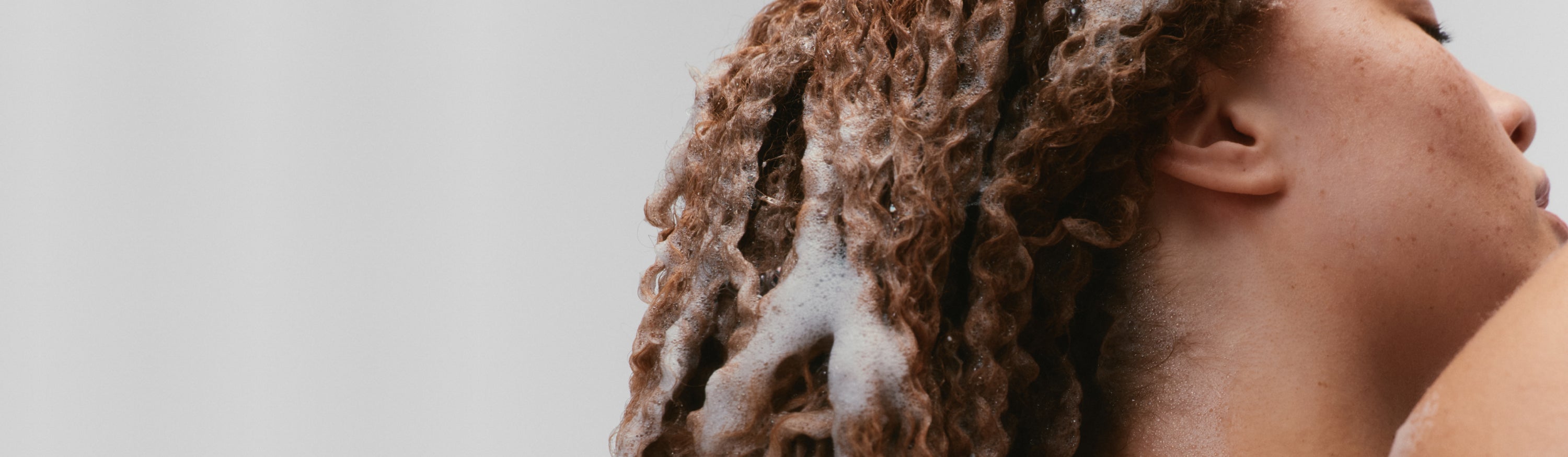Red headed girl in the shower with suds in her hair
