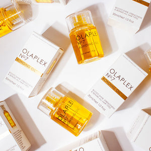 OLAPLEX No.7 Bottles lying diagonally against a pink backdrop