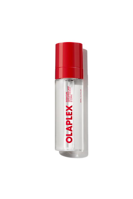 A clear bottle of Olaplex Hair and Body Fragrance Mist featuring a vibrant red cap and the bold Olaplex logo printed vertically down the front, shown against a transparent grid background.