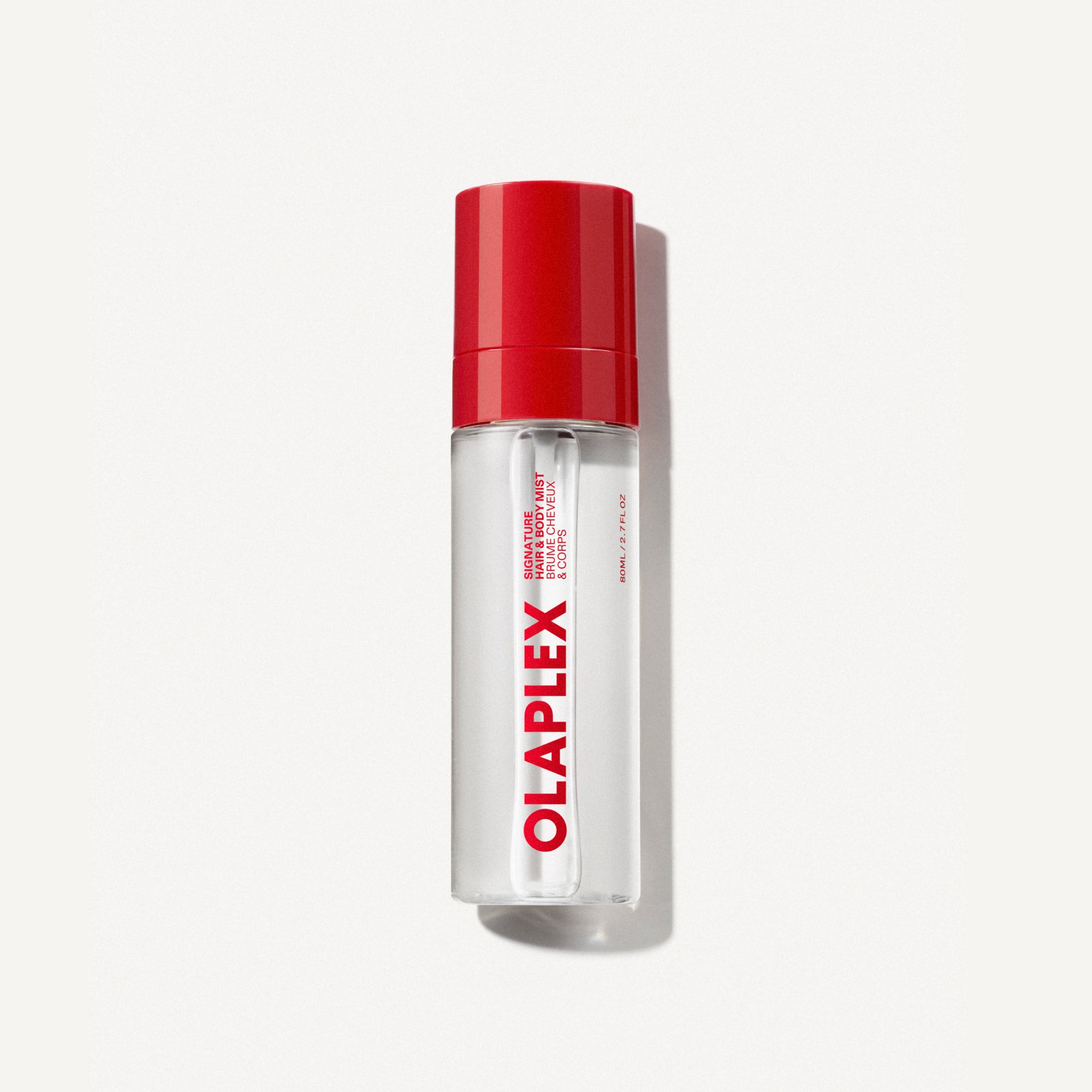 An 80ml clear spray bottle of OLAPLEX Signature Hair and Body Mist featuring a vibrant red cap and a white vertical label with the red OLAPLEX logo. Centered on an off-white background.