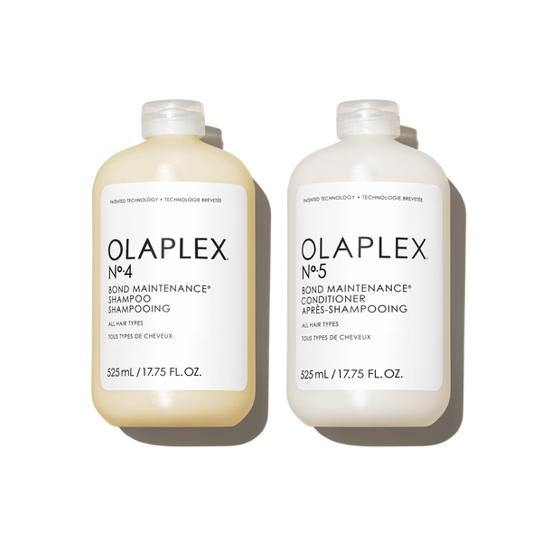 Two Jumbo (525ml) bottles of OLAPLEX N°.4 Bond Maintenance Shampoo and N°.5 Bond Maintenance Conditioner on a transparent background. Each bottle is 525 mL / 17.75 fl. oz. and features clean, minimalist black text branding. - main view